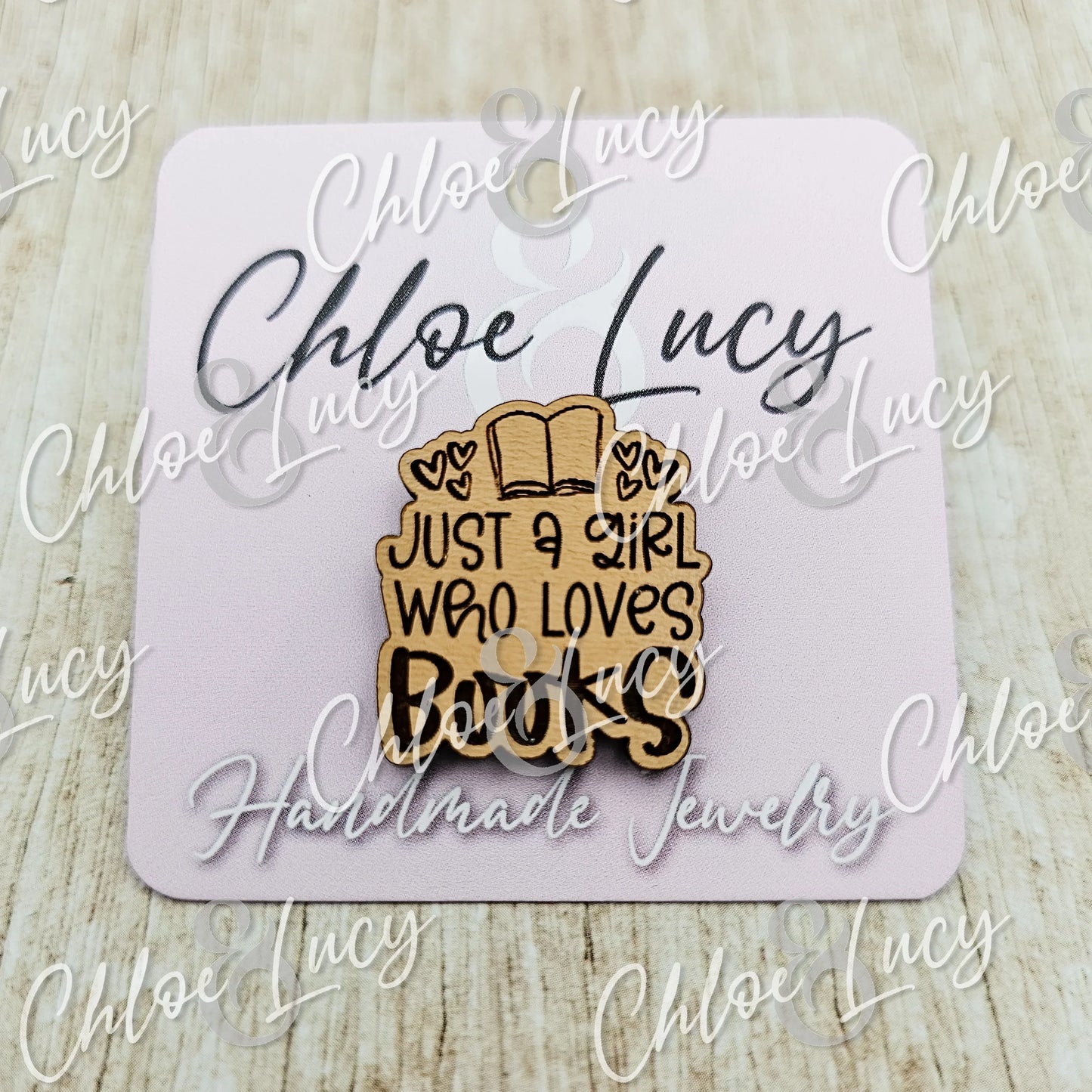 Wooden pin with open book and 'Just a girl who loves books' text on a card backing