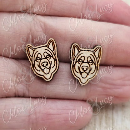 Wooden dog face stud earrings with engraved details on a hand, pet jewelry accessory