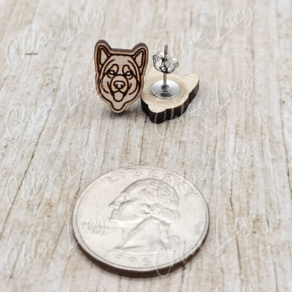 Wooden dog face stud earrings with stainless steel posts next to a US quarter on wood surface