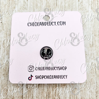 Black enamel cat face pin on a pink display card with social media handles