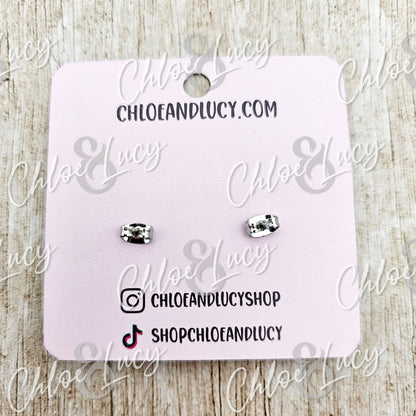 Silver hammered bar stud earrings on a pink display card, minimalist jewelry