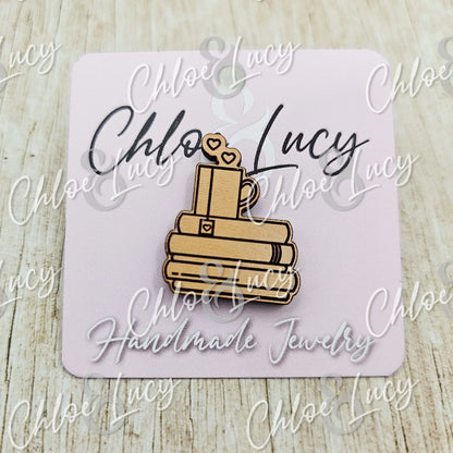 Wooden pin shaped like books with a mug and hearts, displayed on a pink card