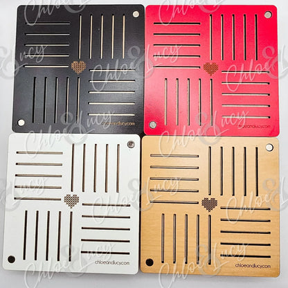Set of four square wooden coasters in black, red, white, and natural with heart pattern and slots.