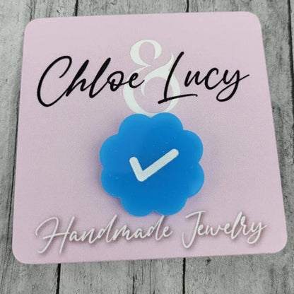 Blue checkmark flower pin on pink card that reads Handmade Jewelry